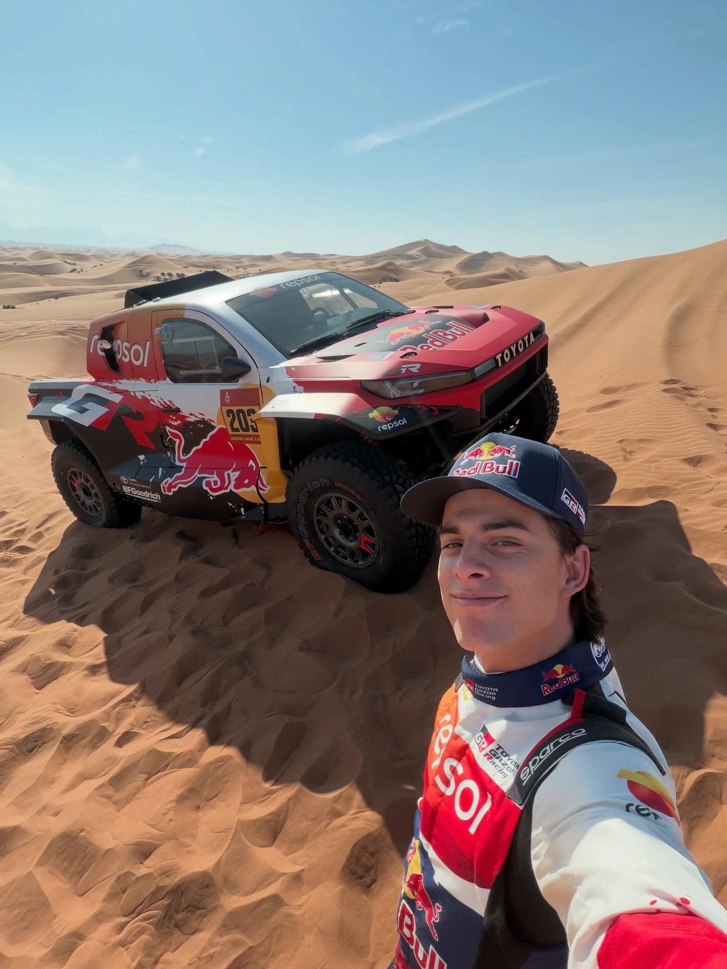 Seth Quintero taking a selfie in front of his Toyota T1+ in the dunes